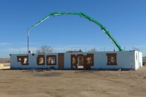 Home under construction using insulated concrete forms (ICF) for foundation, with crane overhead.